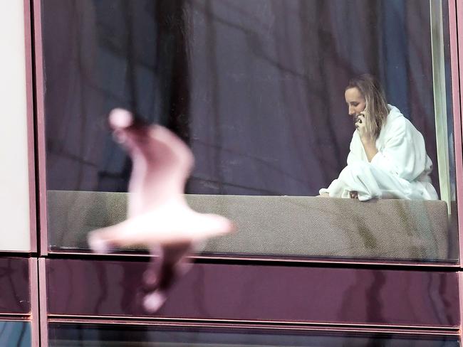 A woman speaks on a phone from an inner-city hotel after returning from overseas. Picture: AFP