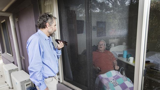 Matthew Fowler visits his father Lionel, 88, through the window of his Newmarch House room. Picture: Dylan Robinson