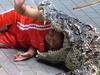 PIC BY IAN MACLEAN / CATERS NEWS - (SHOWN: A crocodile trainer waves with her head in a crocodiles mouth) A fearless croc handler wows onlookers by sliding in and kissing one of the deadly man-eaters on the nose. The male trainer at Pattaya Crocodile Farm risks his life every day for just , alongside his female accomplice. Between them they wow audiences at the Thai zoos croc show with their fearless acts. One stunt sees the male run, slide along the floor before reaching in to kiss the crocodile on the tip of its nose without it even flinching. SEE CATERS COPY.