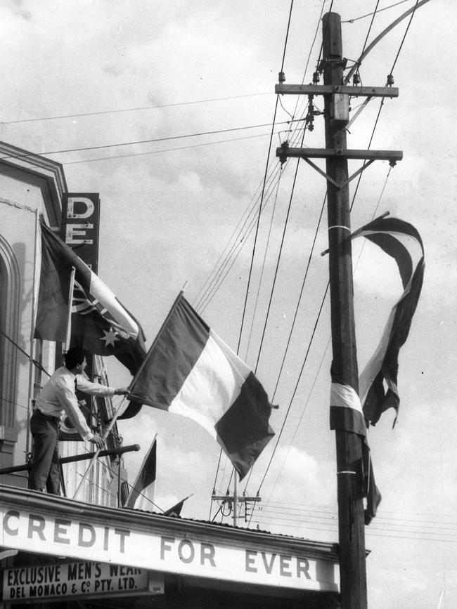 Francis Del Monaco puts yet another Italian flag on the roof of his father's shop in Lygon St, Carlton in 1967.