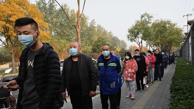 People wait in line to receive Covid-19 vaccination booster shots along a street in Beijing. The outbreak gripping China is "serious” says Beijing officials. Picture: AFP