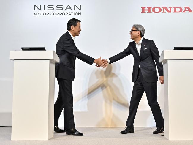 (FILES) This file photo taken on August 1, 2024 shows Makoto Uchida (L), president and CEO of Japanese auto maker Nissan, and Toshihiro Mibe (R), director, president and representative executive officer of auto maker Honda, shaking hands at the start of in a press conference in Tokyo. Nissan shares plunged 4.8 percent on February 5, 2025 after Japan's Nikkei business daily said the carmaker had decided to withdraw from merger talks with rival Honda. (Photo by Richard A. Brooks / AFP)