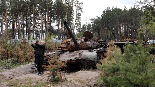 A man takes a selfie with a destroyed Russian tank outside Kyiv. Picture: Gary Ramage