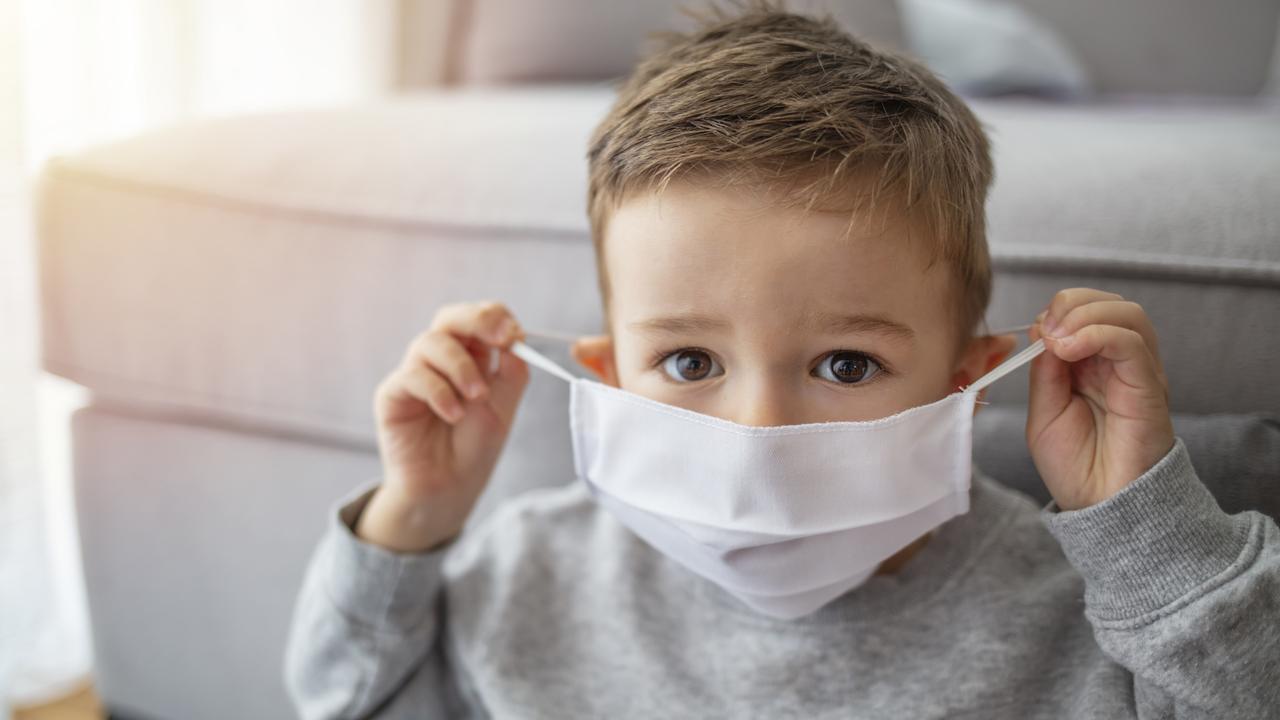 Young child wearing a respiratory mask as a prevention against the Coronavirus Covid-19. Little boy wearing anti virus mask staying at home. Protection against flu and virus infection