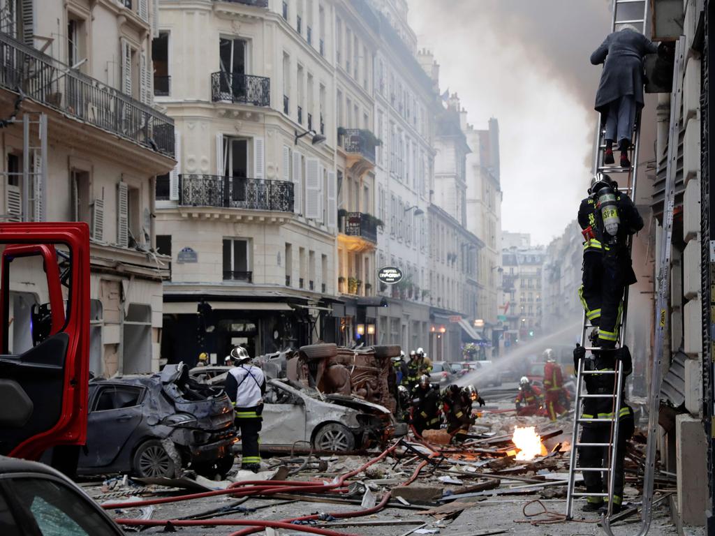 A woman is evacuated by firefighters from an apartment after the explosion of a bakery on the corner of the streets Saint-Cecile and Rue de Trevise in central Paris. Picture: AFP