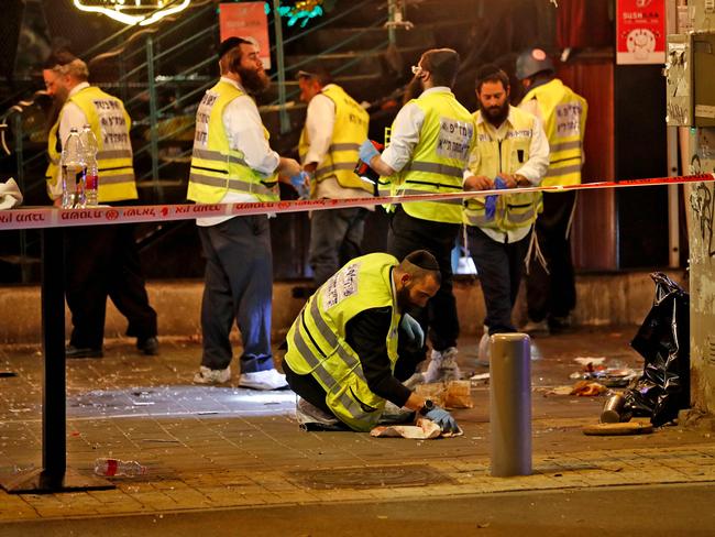 Forensics experts investigate at the scene of a shooting attack in Dizengoff Street in the centre of Israel's Mediterranean coastal city of Tel Aviv on April 7, 2022. - At least two people were killed and several wounded during an attack in the Israeli city of Tel Aviv on April 7, a hospital said. It is the latest incident among a surge of violence in Israel and the West Bank since late March. (Photo by Ahmad GHARABLI / AFP)