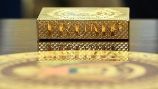 A gold coaster reading "TRUMP" sits on the table in the Oval Office. Picture: AFP