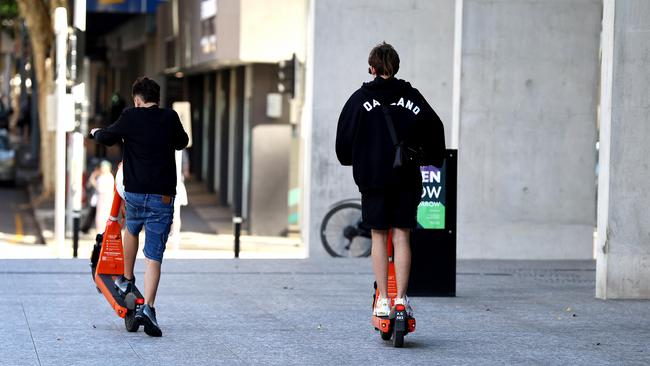 Eshays ride e-scooters without helmets in Brisbane CBD. Picture: David Clark