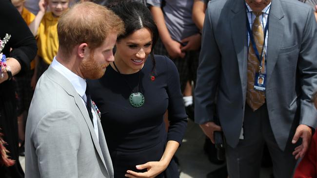 The Duchess of Sussex cradles her baby bump. Photo: Fiona Goodall/Getty Images for Tourism New Zealand