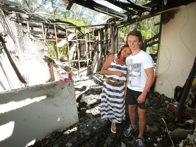 Connor Stewart with his mum Kelli in the ruins of their home. Picture: ADAM WARD