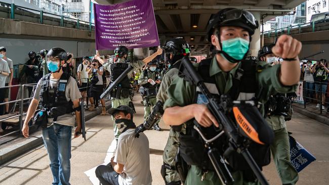 Riot police detain a man as they raise a warning flag during a demonstration against the new national security law in Hong Kong. Picture: Getty Images