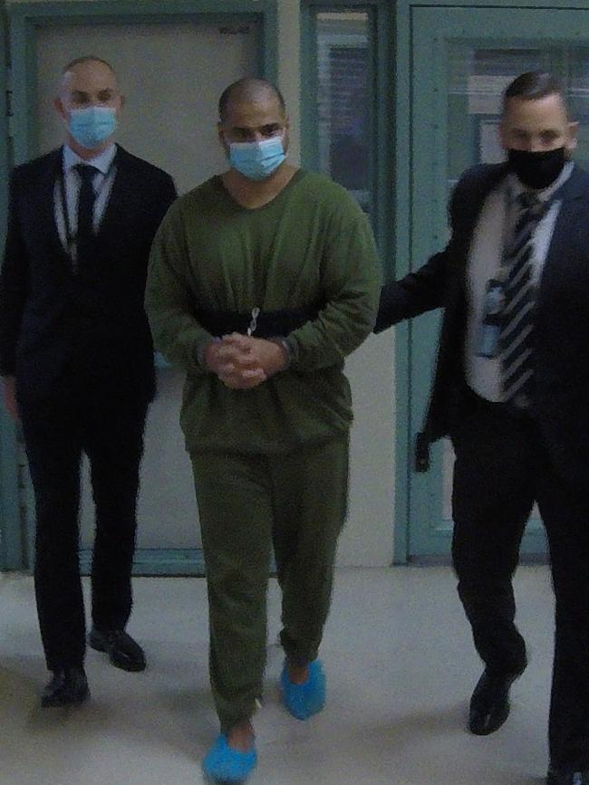 Alleged drug smuggler Mostafa Baluch is led to a NSW Police plane on the Gold Coast wearing shackles and prison greens after a magistrate approved his extradition to NSW. Picture: NSW Police