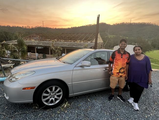 Prabhurat Shanmugaraju and wife Vani from Sydney with their car. Debris from the Upper Coomera holiday home they were staying at with friends smashed though the sunroof and into the passenger seat during the Christmas Day storm. Picture: Keith Woods.