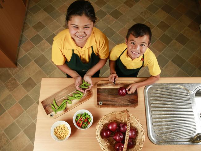 Hebersham Public School students Izaac Mascarenas, 9, and Sulu-Shontaya Loi, 10, take the healthy eating message into the kitchen, where they used fresh vegies from the school garden. Picture: Dylan Robinson