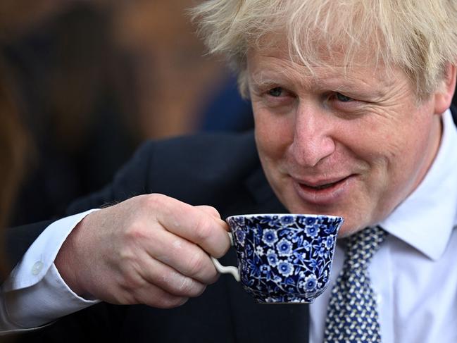 (FILES) In this file photo taken on May 12, 2022 Britain's then prime minister Boris Johnson drinks from a cup as he talks with local business leaders after hosting a cabinet away day in Stoke-on-Trent, central England, on May 12, 2022. Johnson announced his resignation as an MP on June 9, 2023, accusing a parliamentary probe into the 