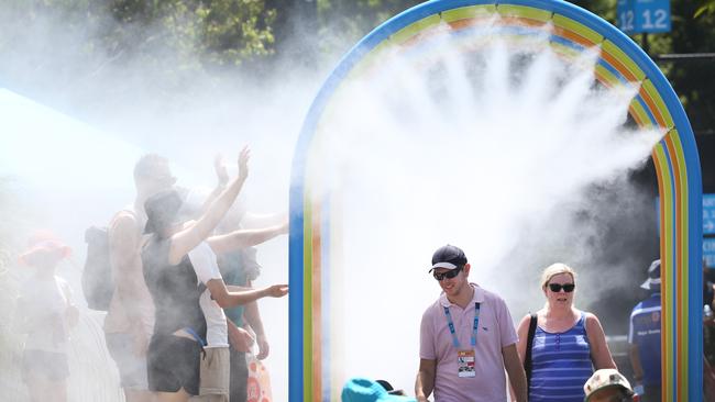 Spectators feeling the heat cool off in around a mist spray tunnel, during a previous Australian Open. Picture: David Caird