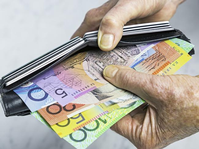 Payment. Close-up, senior female hands taking Australian banknotes (cash, currency) from purse containing many credit cards.  Horizontal, studio, copy space, spread notes.