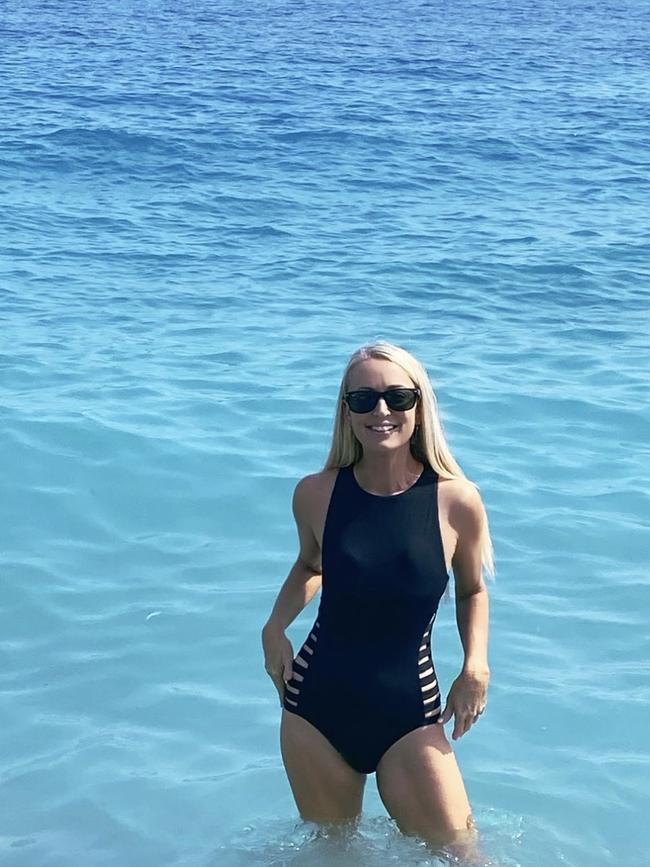 Henderson posed in the water, wearing a cut-out black swimsuit.