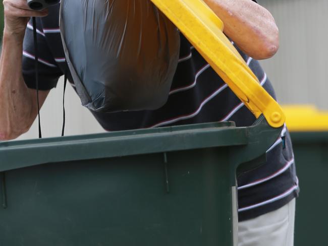 Person with binoculours looking at contents of recycling bin. Picture: Peter Ristevski