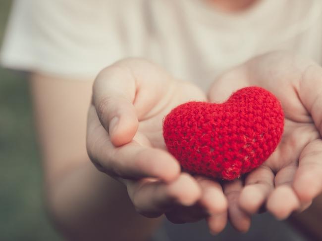 SHWE 0310 Ali Black iStock-927461270 Sharing Love and Heart red color on women hand in valentine's day vintage color tone