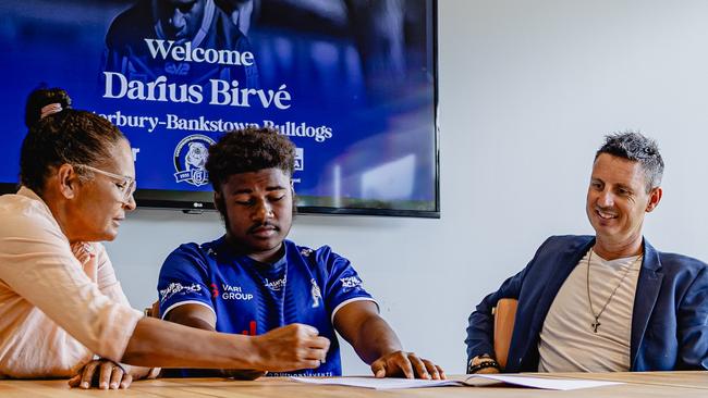 Rising rugby league talent Darius Birve signing with the Canterbury-Bankstown Bulldogs alongside his mother Kathy and manager Justin Smallshaw. Picture: snapsbykobs