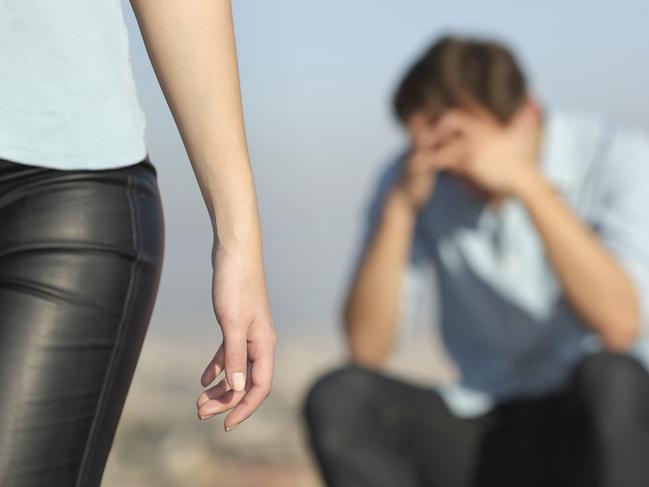 Breakup of a couple with a sad man in the background and the girlfriend leaving him in the foreground