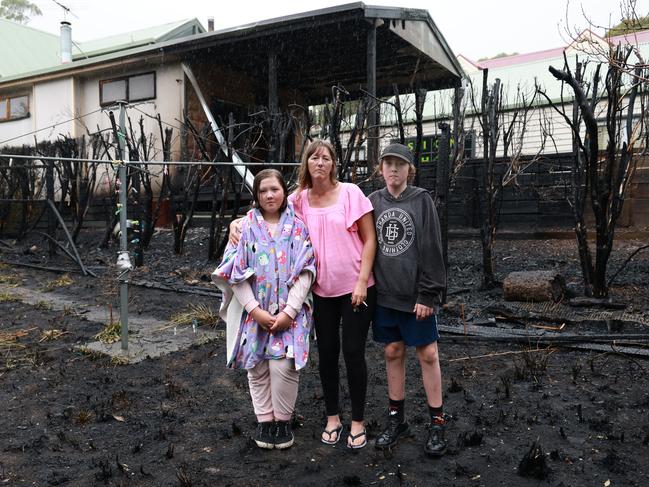 Terry Moyle and her kids Jack 12, and Angel 11, after a raging bushfire scorched their backyard. Picture: David Crosling