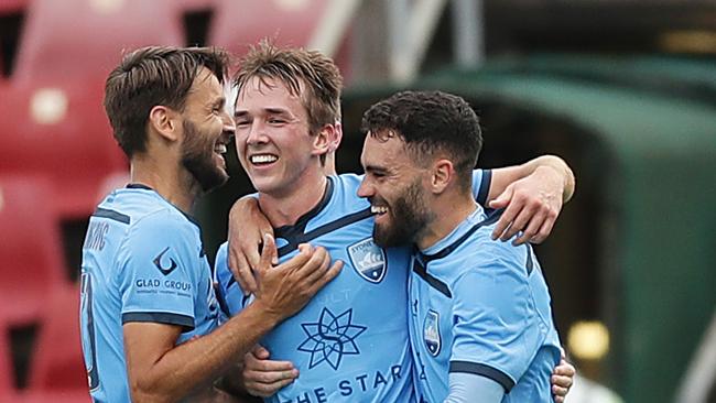 Calem Nieuwenhof celebrates with teammates Milos Ninkovic and Anthony Caceres.