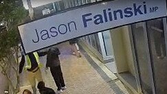 A still from CCTV footage showing a woman, walking her dog, speaking with a man placing a poster for independent candidate Sophie Scamps outside the electorate of sitting Liberal MP Jason Falinski early on Wednesday. Picture: Supplied