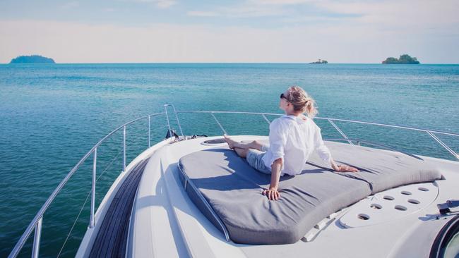 beautiful woman enjoying luxurious yacht cruise, sea travel by luxury boat; rich lifestyle wealth generic