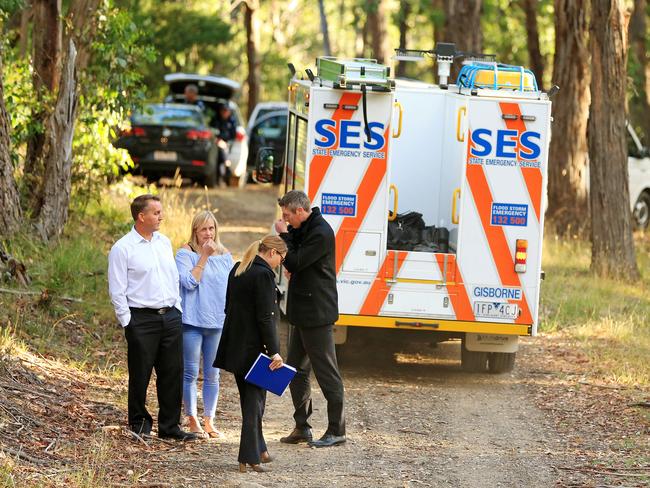 Detectives confer near where the body of a woman was found. Picture: Mark Stewart