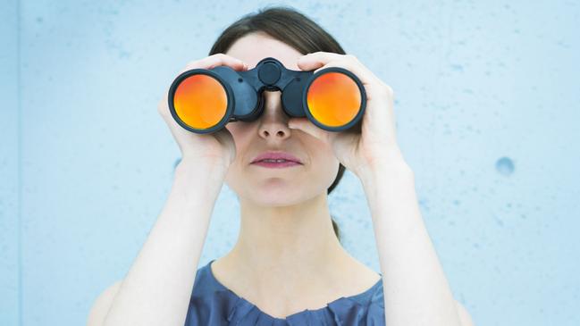 Business vision: woman holding binoculars. istock