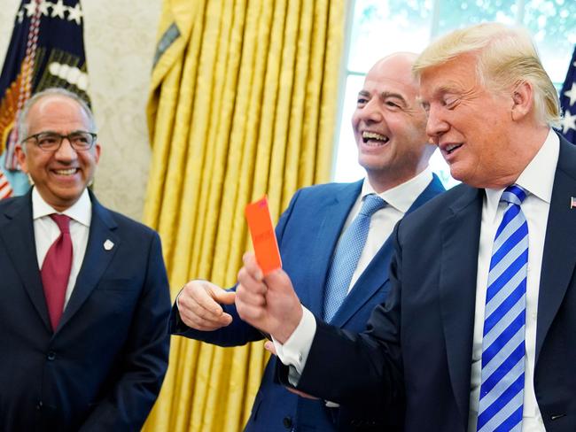 FIFA President Gianni Infantino (C) laughs are US President Donald Trump holds a red card during a meeting in the Oval Office of the White House in Washington, DC on August 28, 2018. Infantino offered Trump a set of yellow and red cards. - At left is US Soccer Federation President Carlos Cordeiro. (Photo by MANDEL NGAN / AFP)