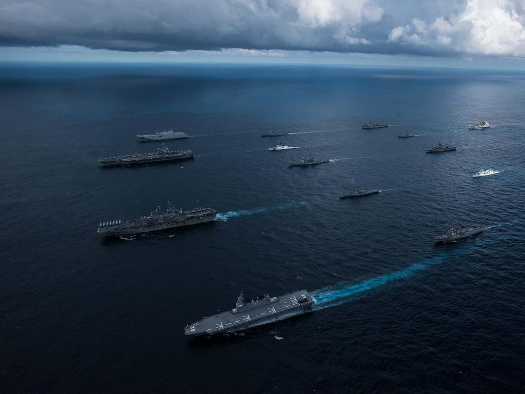 The amphibious assault ship HMAS Canberra (L 02), top left, the aircraft carrier USS Ronald Reagan (CVN 76), top center-left, the amphibious assault ship USS Wasp (LHD 1), bottom center-left, and the Japanese helicopter destroyer JS Ise (DDH 182), bottom left, sail in formation with 13 other ships from the U.S. Navy, U.S. Coast Guard, Royal Australian Navy, Royal Canadian Navy and Japan Maritime Self-Defense Force (JMSDF) during Talisman Sabre 2019. Picture Australian Defence Force