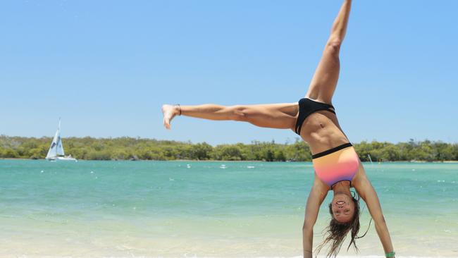 Leilani Ashford practices her gymnast moves at Noosaville as the Noosa River does its best Whitsundays impersonation. Photo Lachie Millard