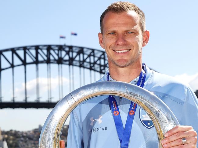 SYDNEY, AUSTRALIA - AUGUST 31:  Alex Wilkinson poses with the A-League Trophy during an A-League media opportunity after Sydney FC won last night's Grand Final, at Sydney Opera House on August 31, 2020 in Sydney, Australia. (Photo by Mark Kolbe/Getty Images)