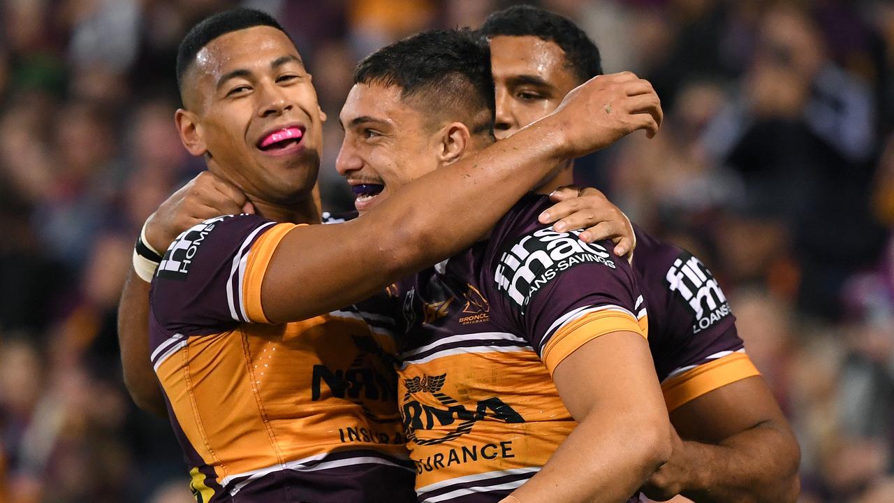 Kotoni Staggs of the Broncos (centre) celebrates a try on Thursday night.