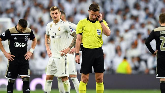 Referee Felix Brych listens to the VAR for Ajax's third goal during their UEFA Champions League round of 16 second leg football clash against Real Madrid earlier this month.