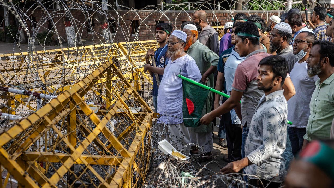 Protesters hold Bangladesh's national flags as they march to block the house of Sheikh Mujibur Rahman, (Photo by LUIS TATO / AFP)