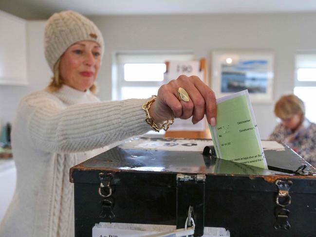 An Islander, Maria McSweeney casts her ballot inside the polling station set up in the living room of an islander, one of the 28 registered to vote, on Gola Island, off the Donegal coast of western Ireland, as voting in the Irish constitution referenda takes place on March 8, 2024. Ireland began voting in a double referendum Friday on proposals to modernise constitutional references to the make-up of a family and women's "life within the home". The votes are the latest attempt to reflect the changing face of Ireland and the waning influence of the once-dominant Catholic Church. (Photo by PAUL FAITH / AFP)