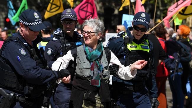 An Extinction Rebellion activist is escorted away by police. Picture: James Ross/AAP.