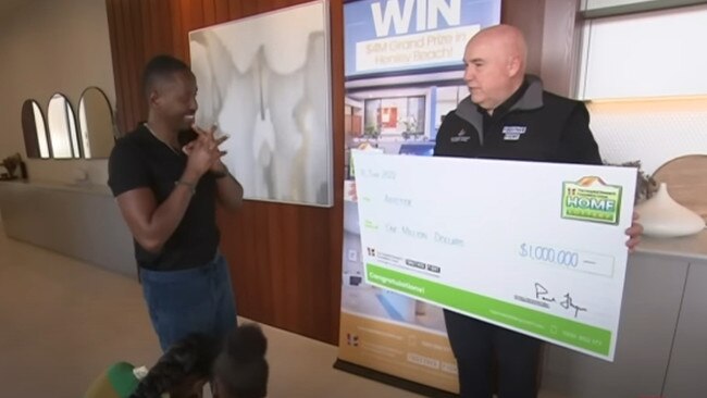 Esther Mboneye is presented with the $1m cheque inside her new home. Picture: 7NEWS