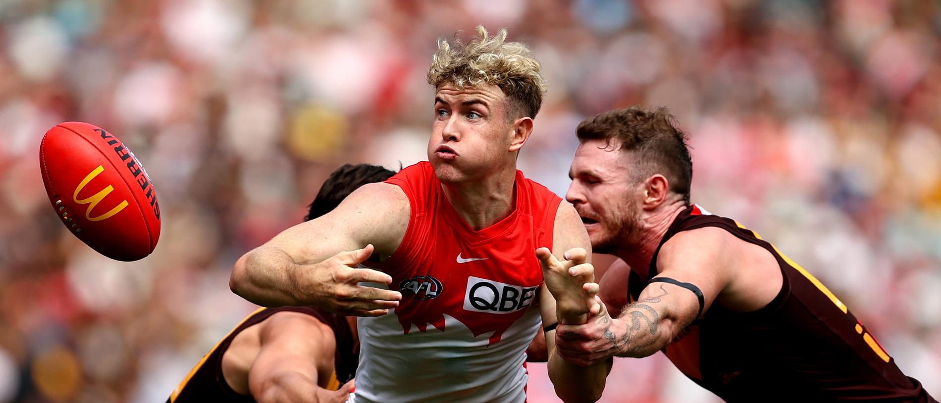 SYDNEY, AUSTRALIA - MARCH 26: Chad Warner of the Swans contests the ball with Connor Macdonald and Blake Hardwick of the Hawks during the round two AFL match between Sydney Swans and Hawthorn Hawks at Sydney Cricket Ground, on March 26, 2023, in Sydney, Australia. (Photo by Brendon Thorne/AFL Photos/via Getty Images)