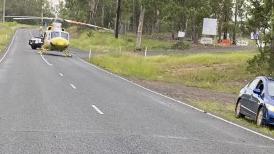 The rescue helicopter was forced to land on the road as emergency crews treated the man. - Pics: RACQ Lifeflight