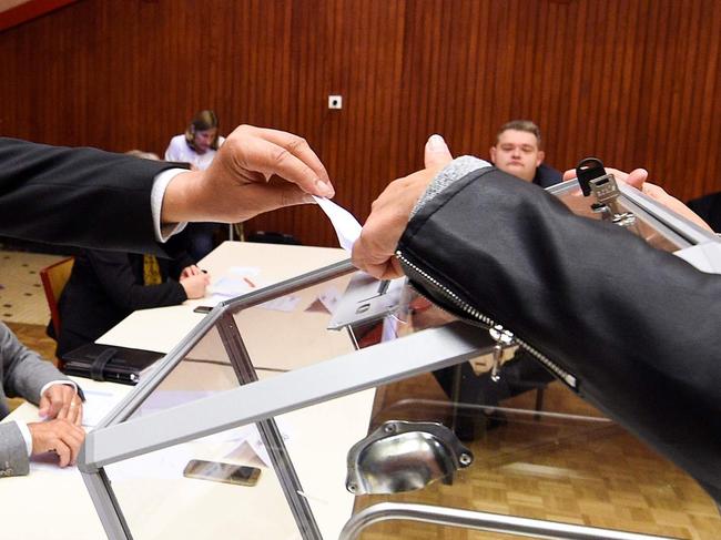 Candidate for the mayoral election Herve Feron (C), casts his vote in the ballot box during the election taking place during a municipal council, in Tomblaine, on May 23, 2020, as France eases lockdown measures taken to curb the spread of the COVID-19 (the novel coronavirus). - Herve Feron will be elected mayor Tomblaine (Photo by JEAN-CHRISTOPHE VERHAEGEN / AFP)