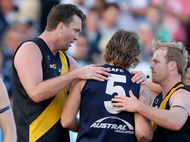 Seaford's Daniel Clarke and Chris Fortnam console Edithvale-Aspendale coach and former Frankston VFL team mate, John Hynes after the MPNFL, Peninsula, Grand Final. Action from the MPNFL, Peninsula, Grand Final between Seaford and