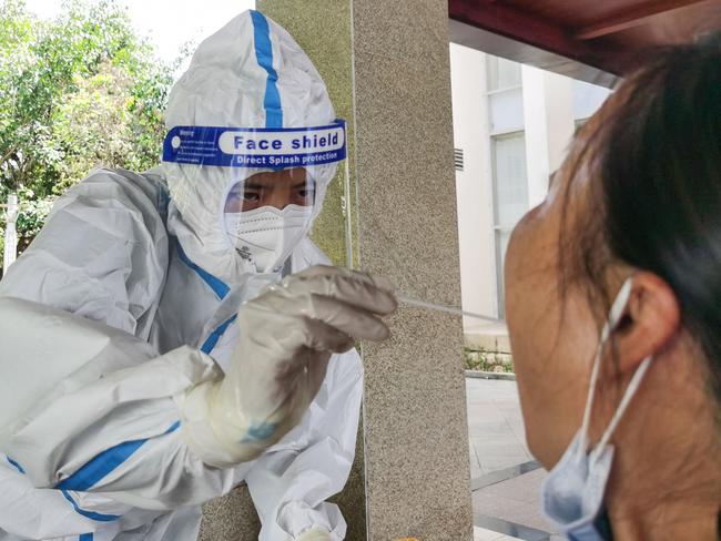 A woman (R) receives nucleic acid testing for the Covid-19 coronavirus at a hotel in the city of Ruili which borders Myanmar, in China's southwestern Yunnan province on July 8, 2021. (Photo by STR / AFP) / China OUT