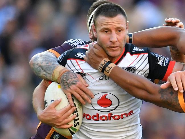 Blake Green (centre) of the Warriors is tackled by Josh McGuire (left) and Joe Ofahengaue (right) of the Broncos during the Round 18 NRL match between the Brisbane Broncos and the Warriors at Suncorp Stadium in Brisbane, Sunday, July 15, 2018. (AAP Image/Darren England) NO ARCHIVING, EDITORIAL USE ONLY