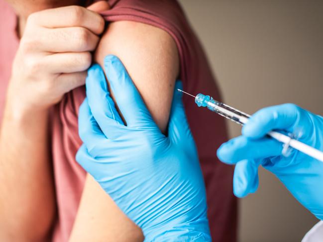 Close up of arm of boy getting vaccinated by doctor holding a needle. Getty stock image