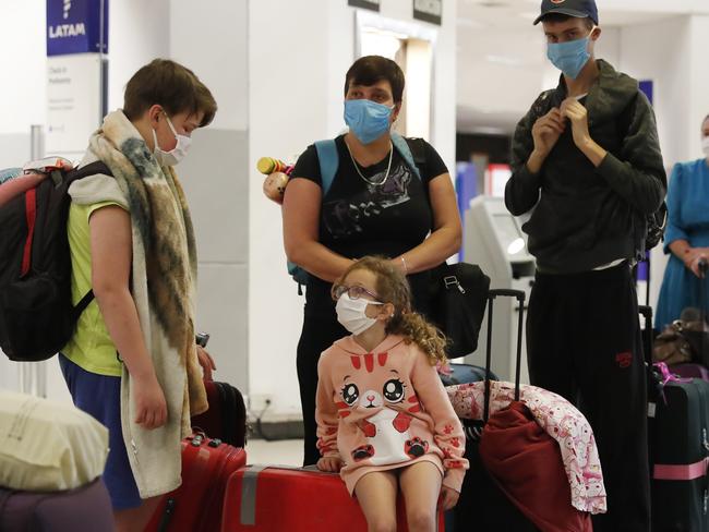 A family waits for a flight to Miami, Florida, from Silvio Pettirossi airport in Luque, on the outskirts of Asuncion, Paraguay, Thursday, April 23, 2020. Paraguay's government has organized with several other nations to get their nationals home, amid a lack of flights due to the global lockdown to contain the spread of the new coronavirus. (AP Photo/Jorge Saenz)